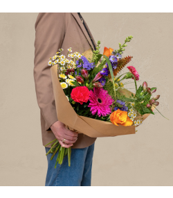 Fyldig buket med farverige blomster og grønne detaljer – eksklusive sæsonblomster til levering i Danmark