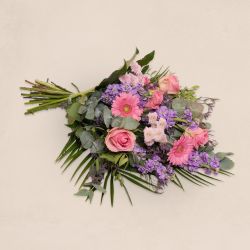 Bårebuket til begravelse. En bårebuket med blomster i lyserøde, lavendel og lilla farver. Bårebuket til kirke.