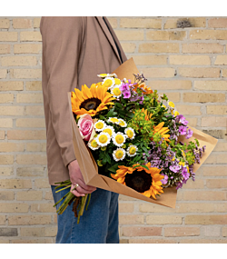 Sommer solsikkebuket med solsikker, floks, limonium, grenede krysantemum og roser bundet med pistache og hareøre – en fyldig og sæsonaktuel blomsterbuket, perfekt som gave, sommerhilsen eller blomsterlevering til hjemmet.